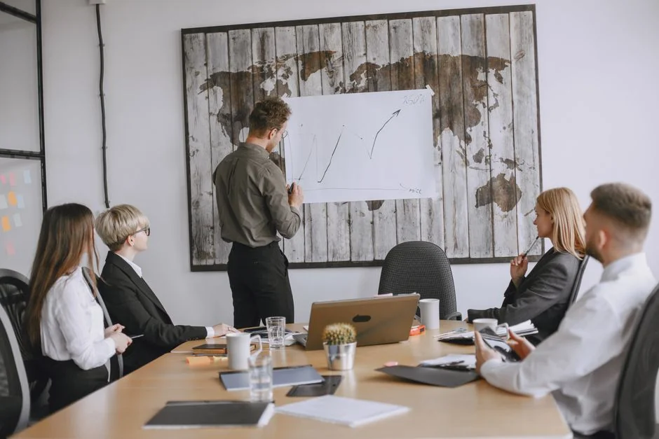 Top view of diverse colleagues in a business meeting discussing strategies with charts and laptops.